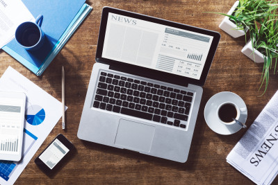 Life science industry news online on a laptop with coffee and stationery